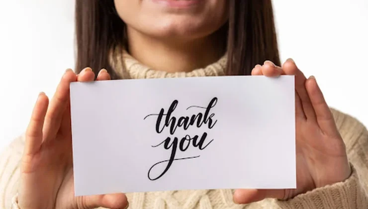 up close of a girl holding a thank you note up close